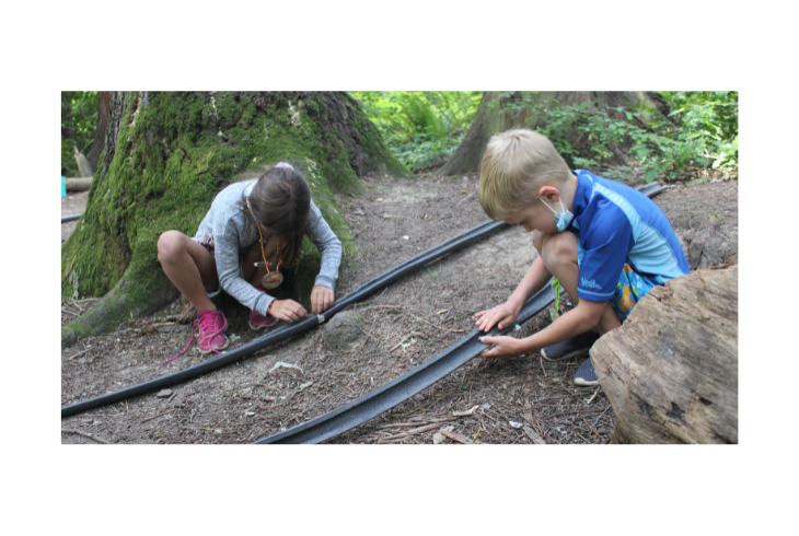 Campers at the Tualatin Hills Nature Park and Cooper Mountain are not just visitors but active participants in a world that unfolds around them. Campers spend time outdoors, making friends, and learning new things. Children in this photo are experimenting with STEM models.