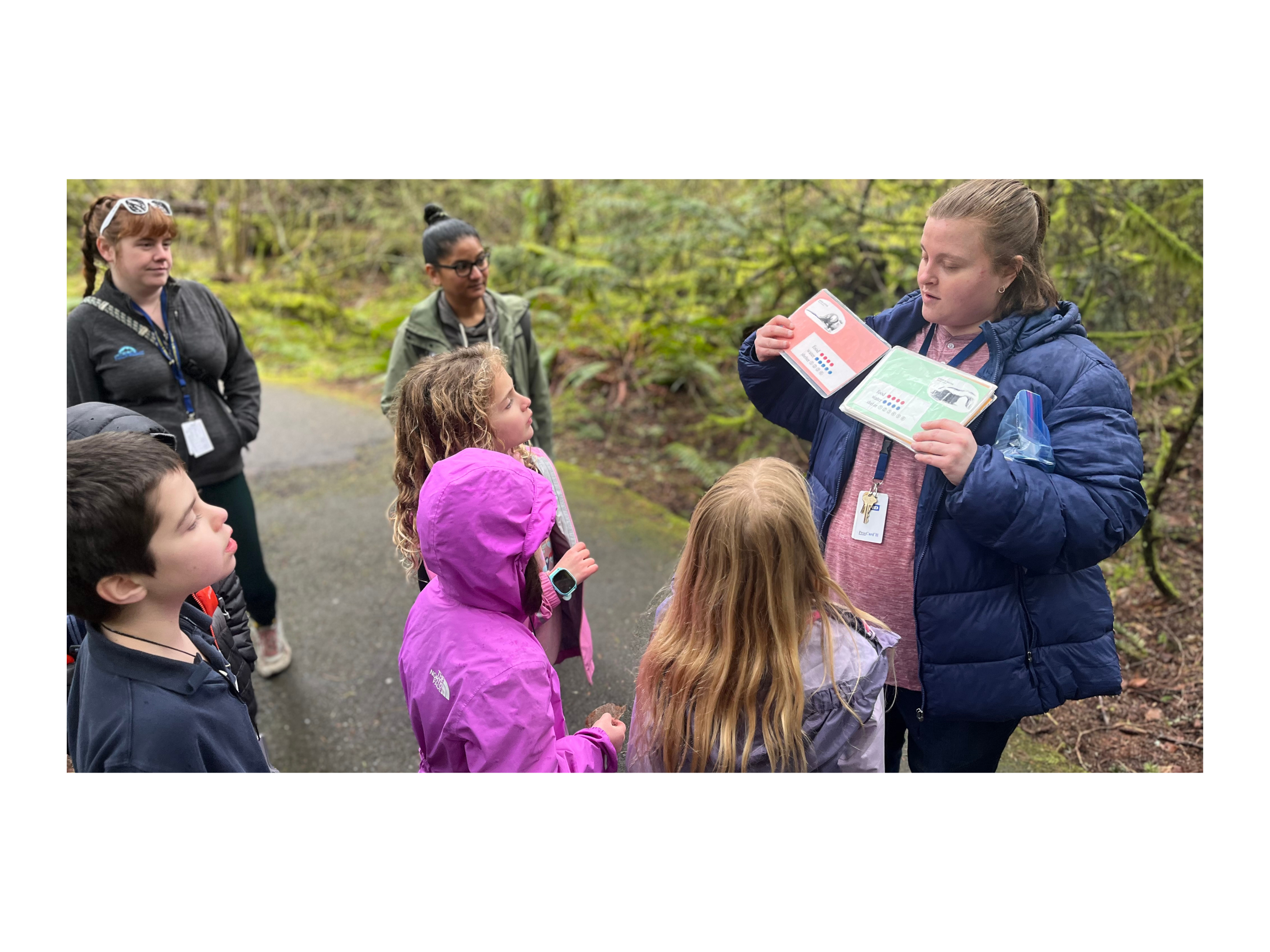 Elementary students out on the trail at Tualatin Hills Nature Park getting ready to start a hands-on activity to learn about habitats.